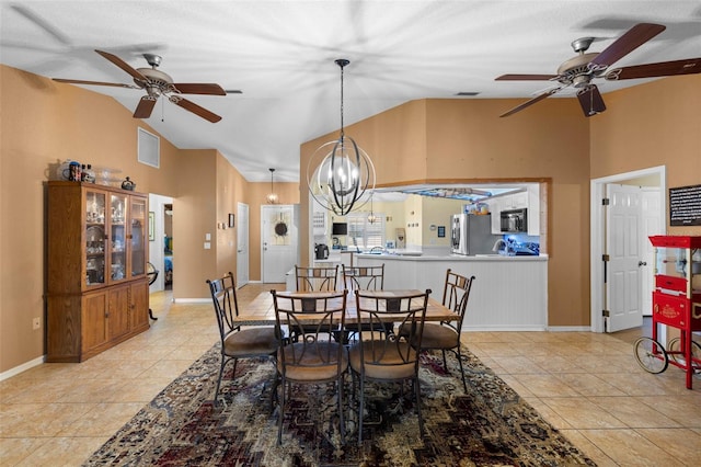 tiled dining space with ceiling fan with notable chandelier and lofted ceiling