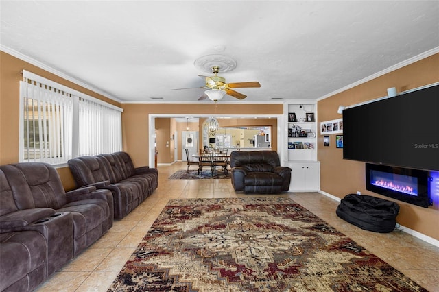 living room with ceiling fan, built in features, light tile patterned floors, and ornamental molding