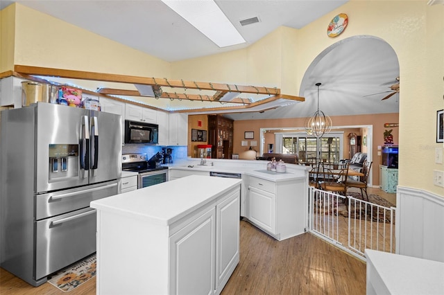 kitchen featuring a center island, white cabinetry, light hardwood / wood-style floors, kitchen peninsula, and stainless steel appliances