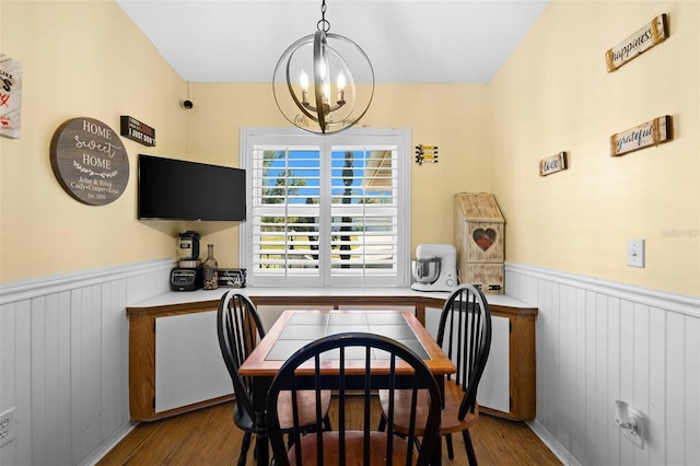 dining area with wood-type flooring and an inviting chandelier