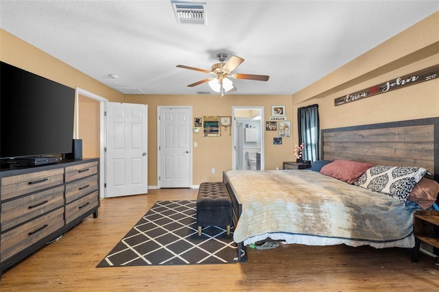 bedroom featuring ceiling fan, light wood-type flooring, and connected bathroom