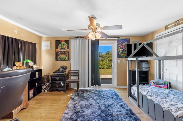 bedroom with access to exterior, light hardwood / wood-style floors, and ceiling fan