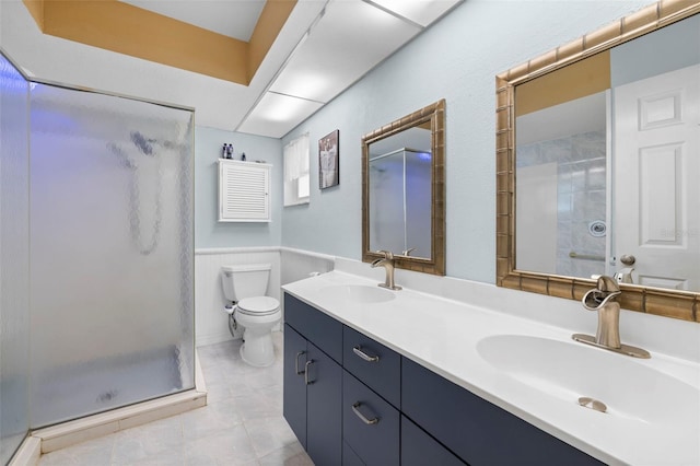 bathroom featuring tile patterned flooring, a shower with door, vanity, and toilet