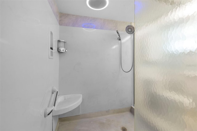 bathroom with concrete floors and a shower with shower door