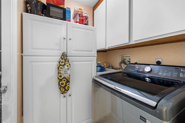 washroom featuring cabinets and washer / dryer