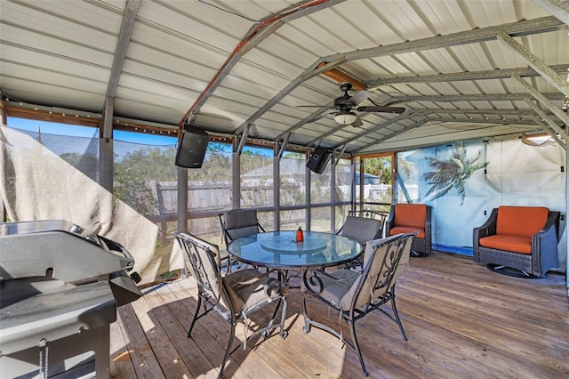 sunroom featuring lofted ceiling with beams, a healthy amount of sunlight, and ceiling fan