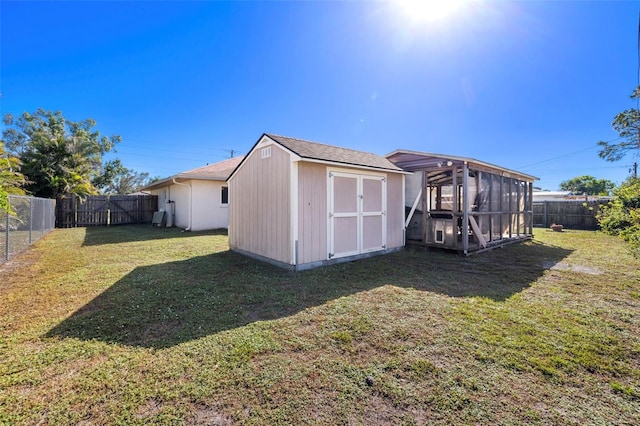 back of property featuring a lawn and a storage shed