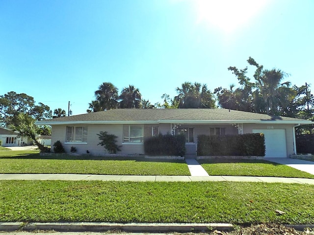 single story home with a garage and a front lawn