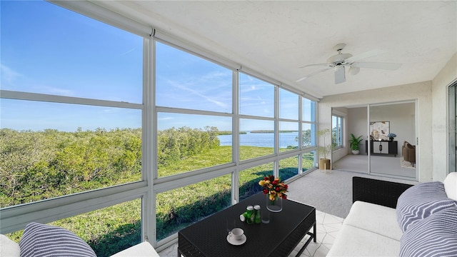 sunroom / solarium featuring a water view and ceiling fan