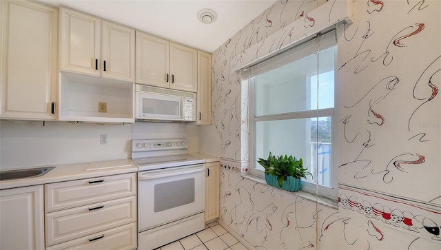 kitchen featuring sink, light tile patterned floors, and white appliances