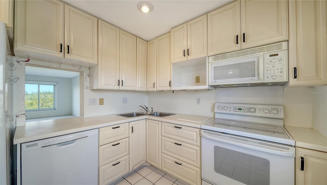 kitchen featuring light tile patterned floors, white appliances, and sink