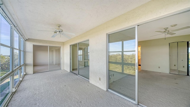 unfurnished sunroom with ceiling fan