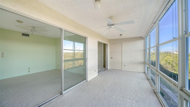 unfurnished sunroom with ceiling fan