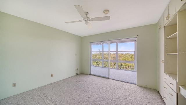 unfurnished bedroom featuring ceiling fan, light colored carpet, and access to outside