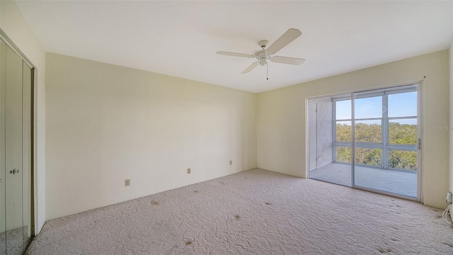 carpeted spare room featuring ceiling fan