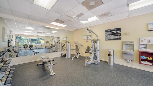 workout area with a paneled ceiling and ceiling fan