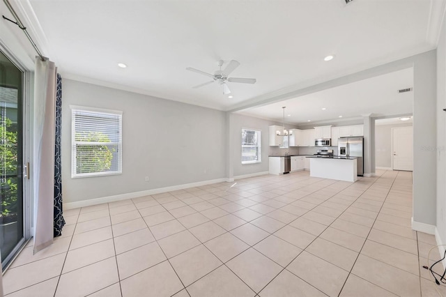 unfurnished living room featuring ceiling fan, a healthy amount of sunlight, and light tile patterned floors