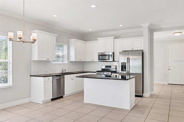 kitchen with appliances with stainless steel finishes, white cabinetry, and a healthy amount of sunlight