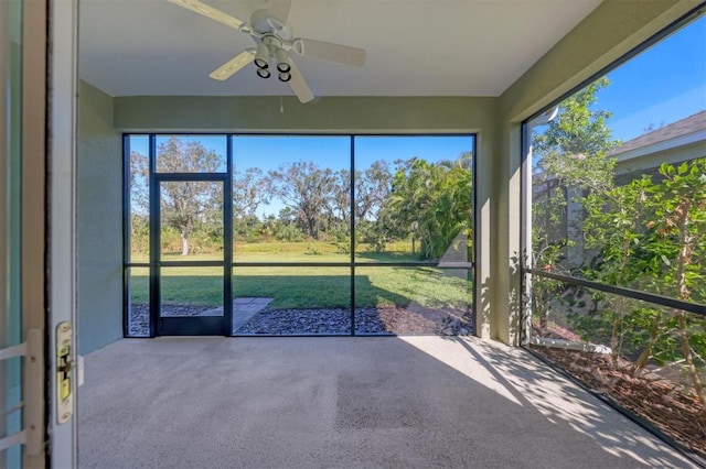 unfurnished sunroom with ceiling fan