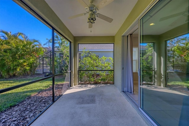 unfurnished sunroom with ceiling fan