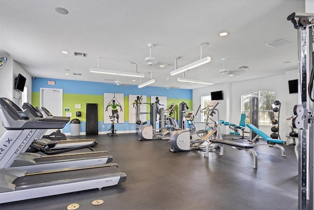 exercise room featuring ceiling fan and a textured ceiling