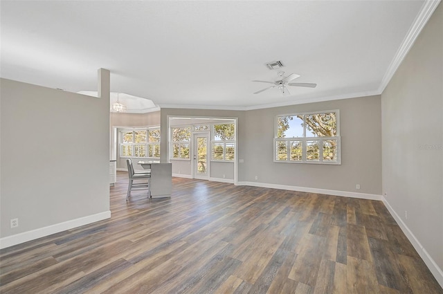 unfurnished living room featuring ceiling fan with notable chandelier, crown molding, and dark wood-type flooring