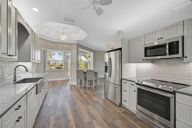 kitchen with tasteful backsplash, stainless steel appliances, crown molding, dark wood-type flooring, and sink