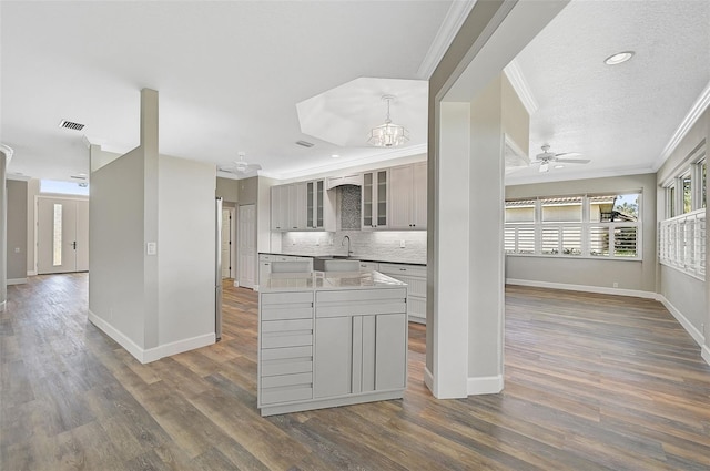 kitchen featuring ornamental molding, dark wood-type flooring, tasteful backsplash, and gray cabinetry