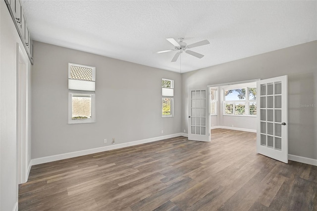 unfurnished room featuring a textured ceiling, ceiling fan, french doors, and dark hardwood / wood-style floors