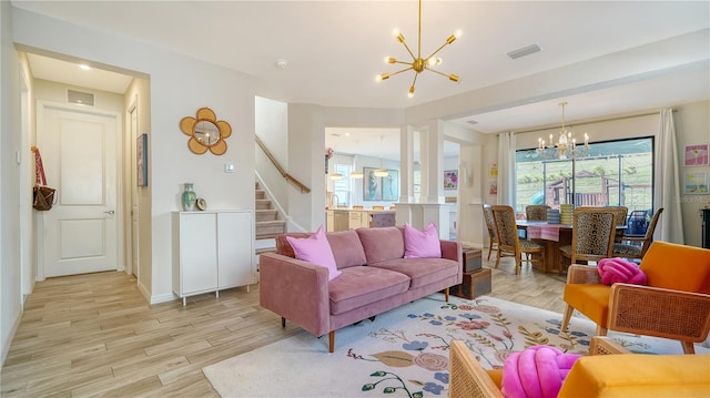 living room featuring a chandelier and light wood-type flooring