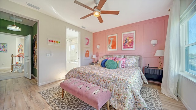 bedroom featuring ceiling fan, connected bathroom, and light hardwood / wood-style floors