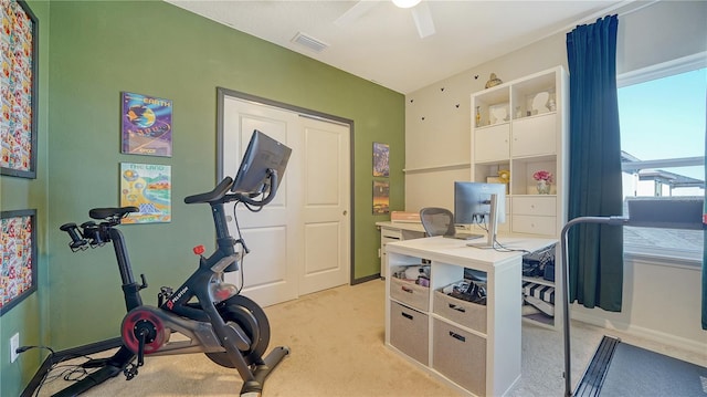 exercise room featuring light carpet and ceiling fan