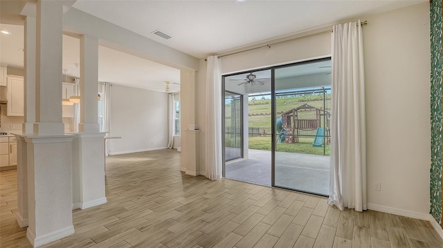 doorway to outside featuring decorative columns, ceiling fan, and light hardwood / wood-style flooring