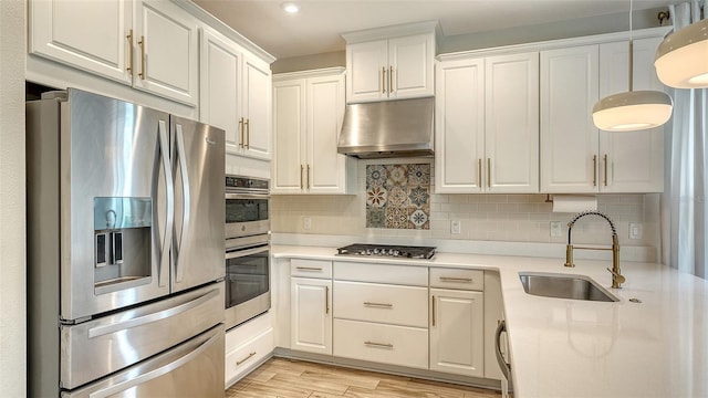 kitchen featuring sink, decorative backsplash, stainless steel appliances, and white cabinets