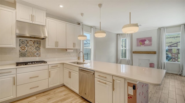 kitchen featuring sink, white cabinetry, stainless steel appliances, decorative light fixtures, and kitchen peninsula