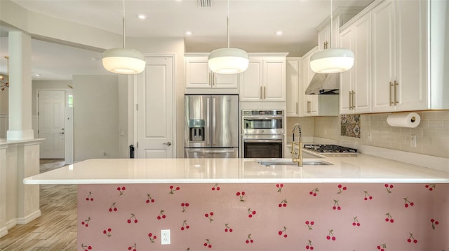 kitchen with pendant lighting, white cabinetry, stainless steel appliances, and kitchen peninsula