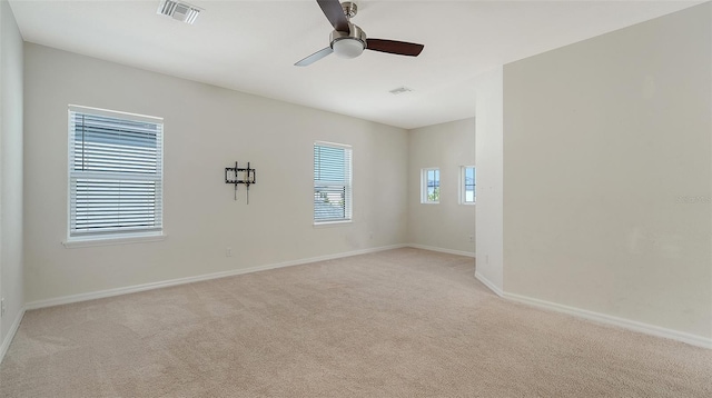 spare room featuring light colored carpet and ceiling fan