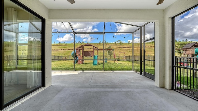 unfurnished sunroom with a rural view and ceiling fan