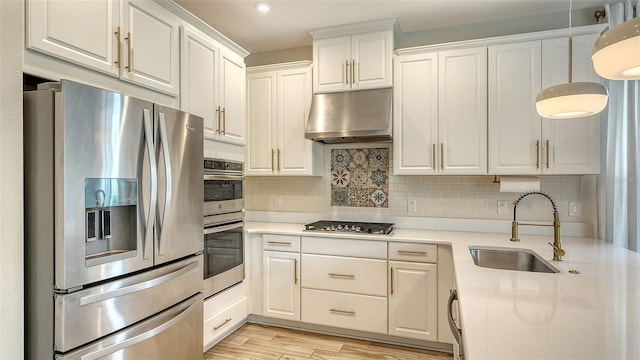 5548 Summit Gln, Bradenton, FL 34203 - kitchen with appliances with stainless steel finishes, under cabinet range hood, light countertops, white cabinetry, and backsplash