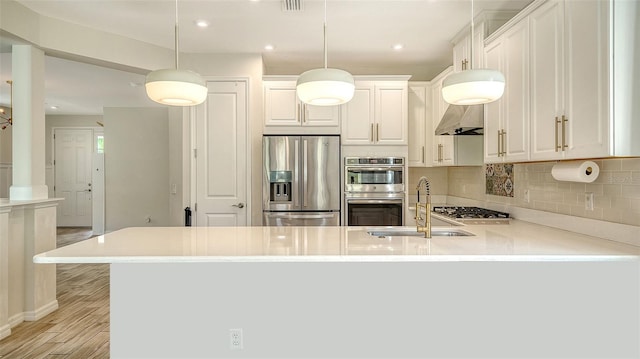 5548 Summit Gln, Bradenton, FL 34203 - kitchen featuring appliances with stainless steel finishes, a peninsula, backsplash, light countertops, and white cabinets