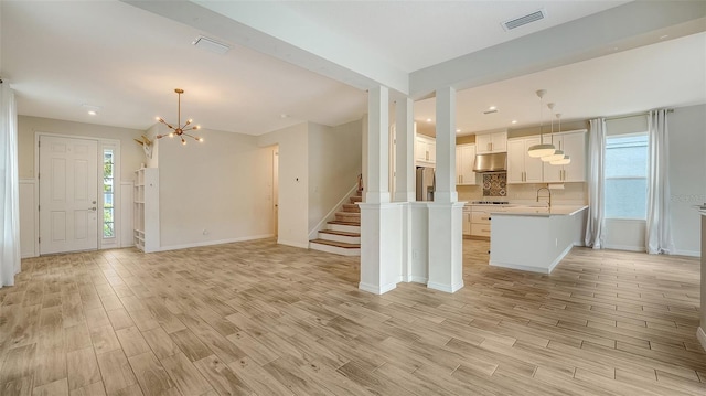 5548 Summit Gln, Bradenton, FL 34203 - unfurnished living room with light wood-style floors, a chandelier, stairs, and recessed lighting
