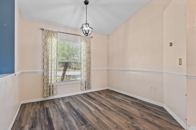 empty room featuring dark hardwood / wood-style floors and a chandelier