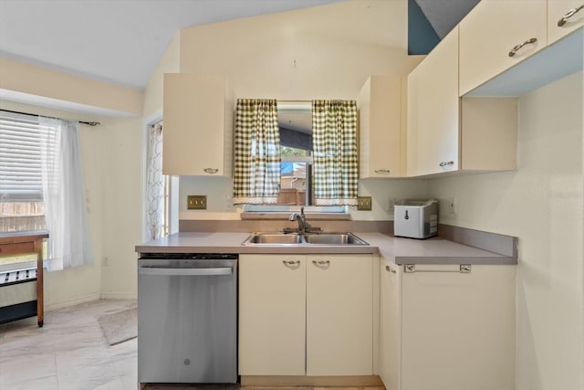 kitchen featuring dishwasher, cream cabinets, vaulted ceiling, and sink