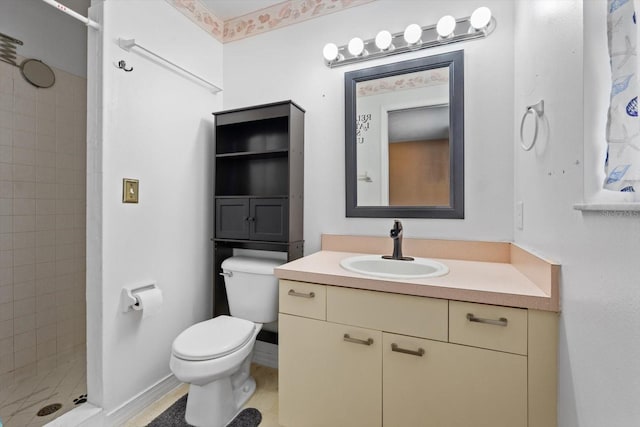 bathroom with a tile shower, vanity, and toilet