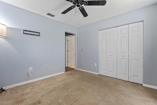 unfurnished bedroom featuring ceiling fan, a closet, and light colored carpet