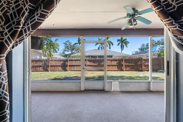 unfurnished sunroom featuring ceiling fan