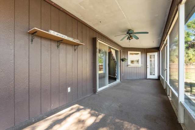 unfurnished sunroom with ceiling fan