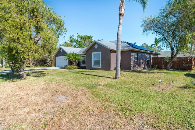 view of side of property with solar panels, a garage, and a lawn