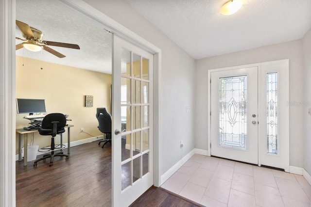 entrance foyer with a textured ceiling, ceiling fan, light hardwood / wood-style flooring, and french doors