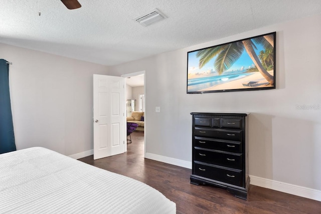 bedroom with ceiling fan, dark wood-type flooring, and a textured ceiling